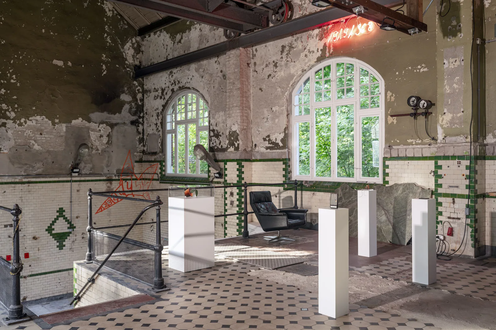 Neue Erinnerungen: alte Industriehalle mit Kachelwänden, weißen Sockeln und hohen Fenstern