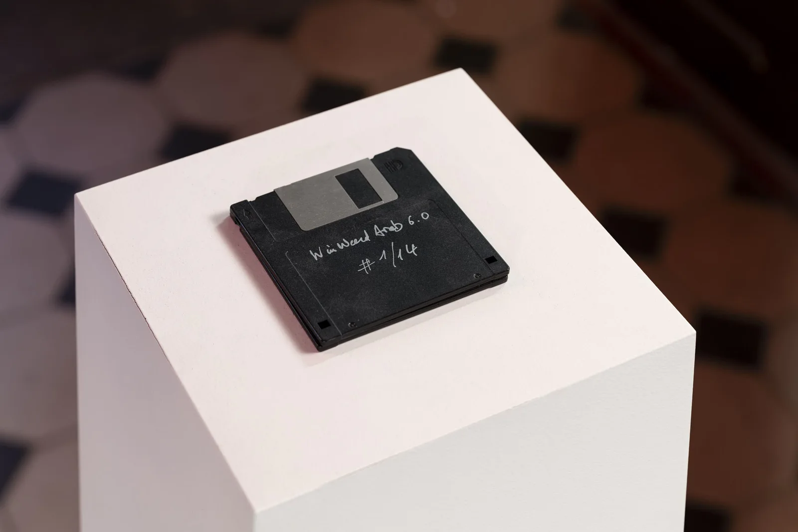 Neue Erinnerungen: eine schwarze 3,5-Zoll-Diskette mit handschriftlicher Notiz auf einem weißen Sockel