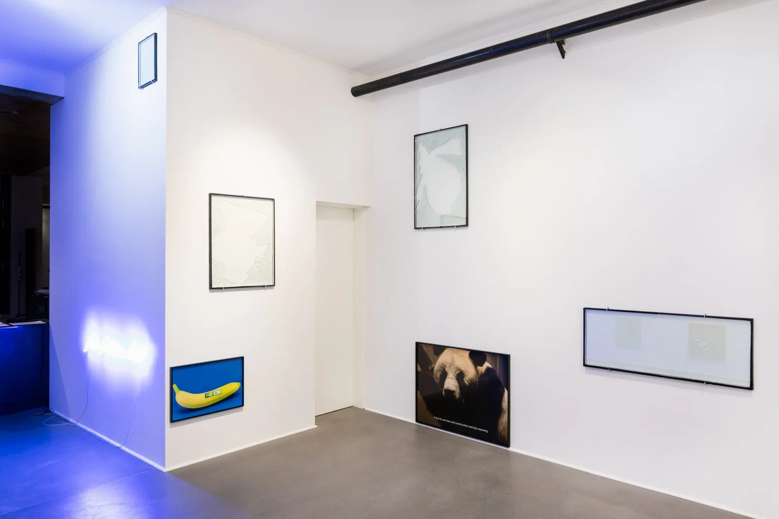 Everything about the contemporary is panda, Installationsansicht: Galerieraum mit leeren Rahmen, Panda-Bildern, einem Bananenbild und blauem Licht