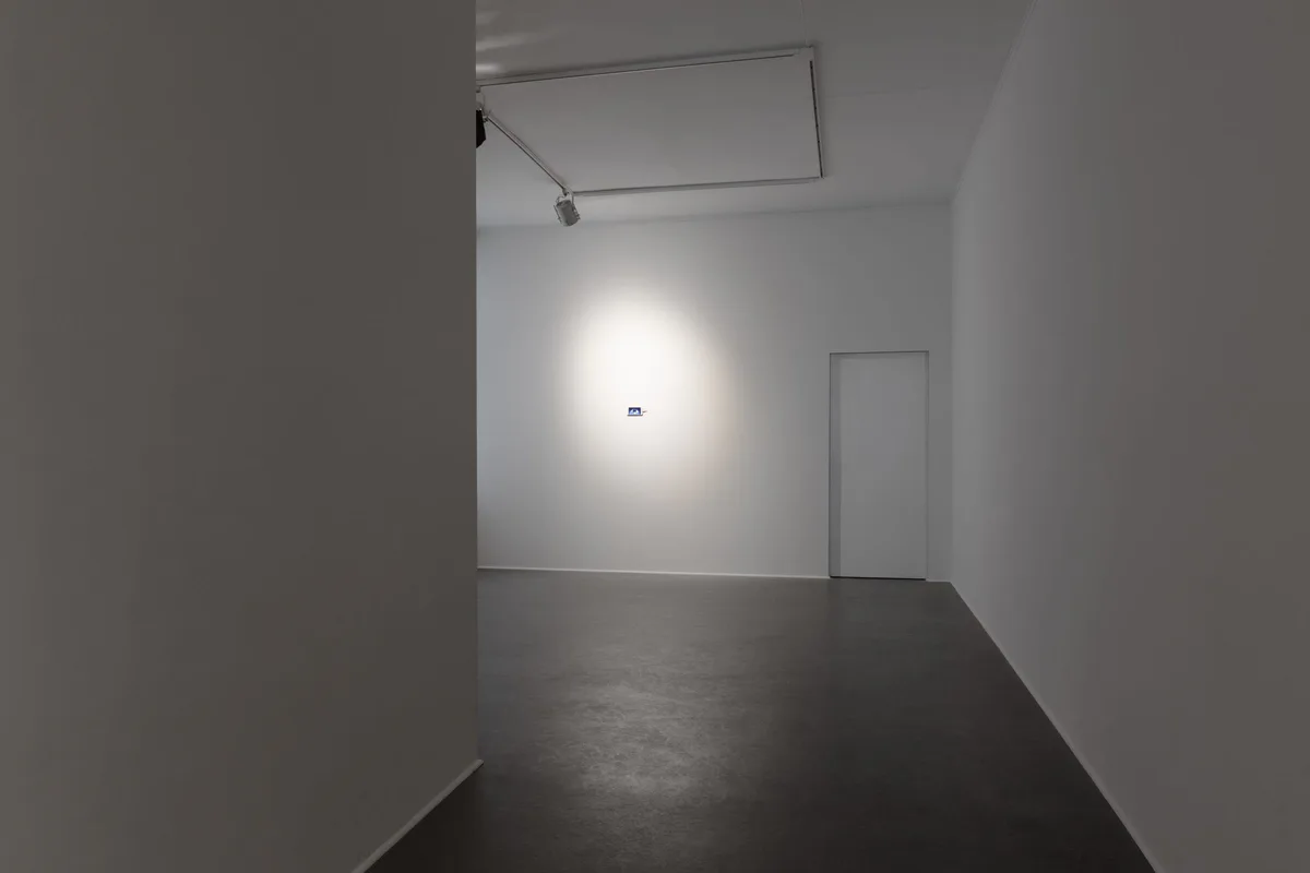 Josephine, history is happening today, 2017, HD-Video, 3 Min.: ein kleines Smartphone allein an einer weißen Wand am Ende eines Flurs