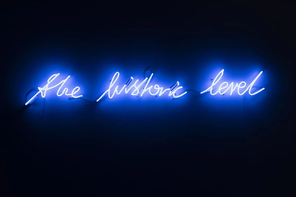 Michal Martychowiec, the historic level, 2017: blaue Neonschrift „the historic level“ in der Dunkelheit