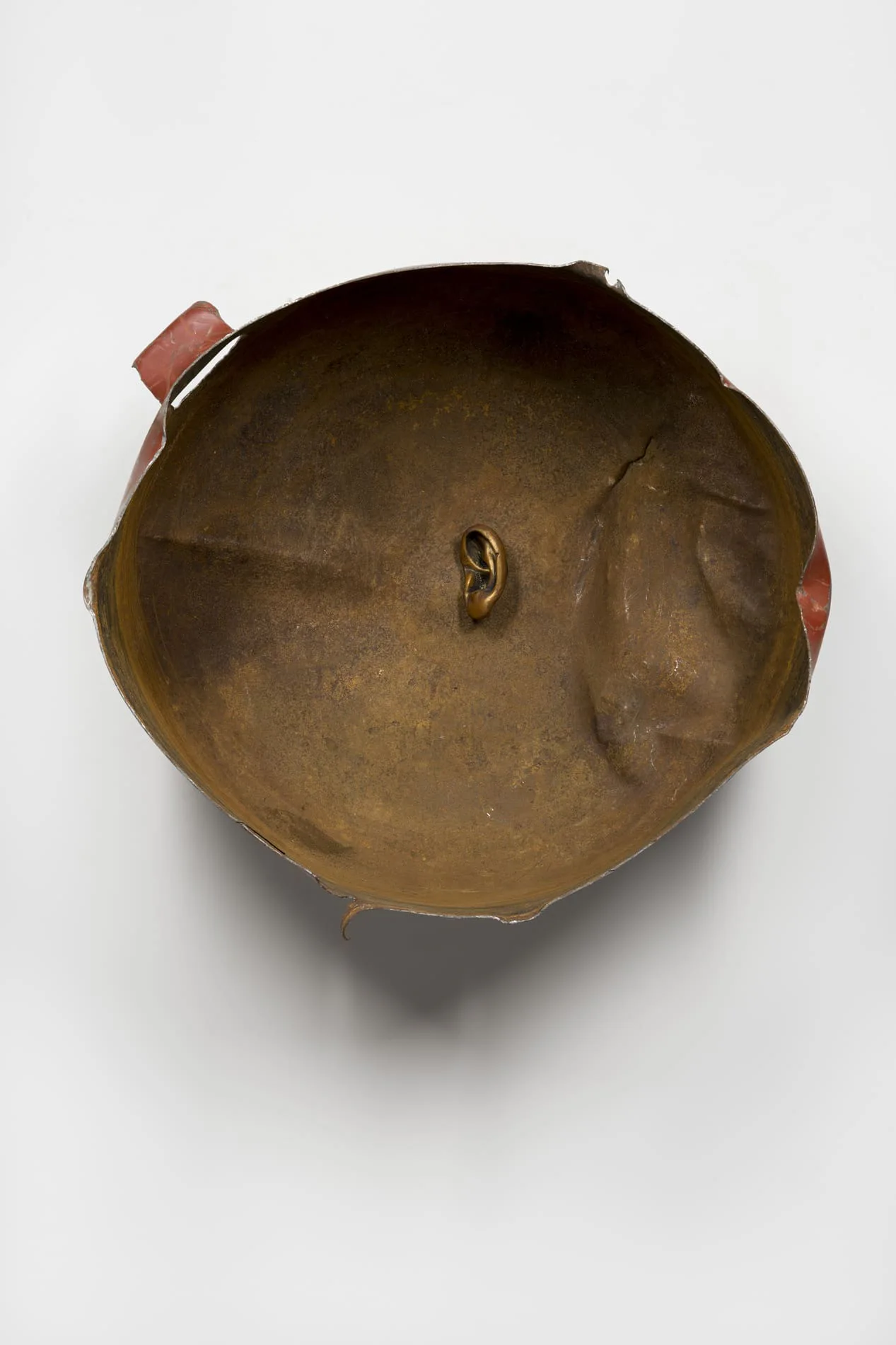 JMH Schindele, Das rechte Ohr des Augustus, 2025: rostige, aufgeschnittene Metallschale an einer weißen Wand