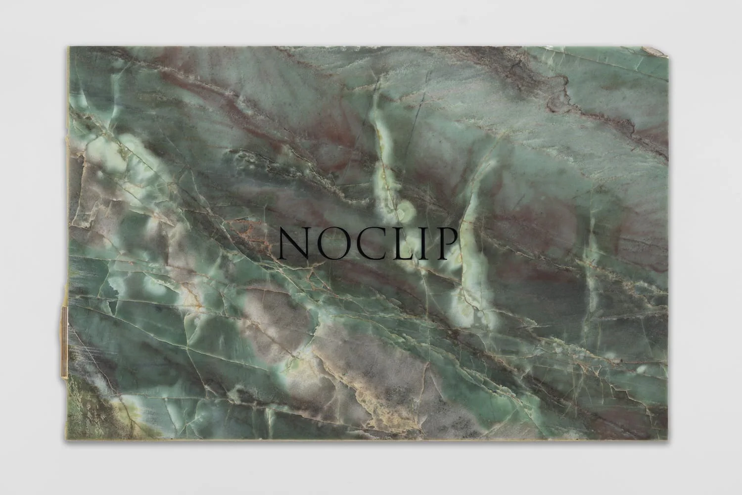 JMH Schindele, NOCLIP, 2026: grüne Marmorplatte mit der Gravur „NOCLIP“