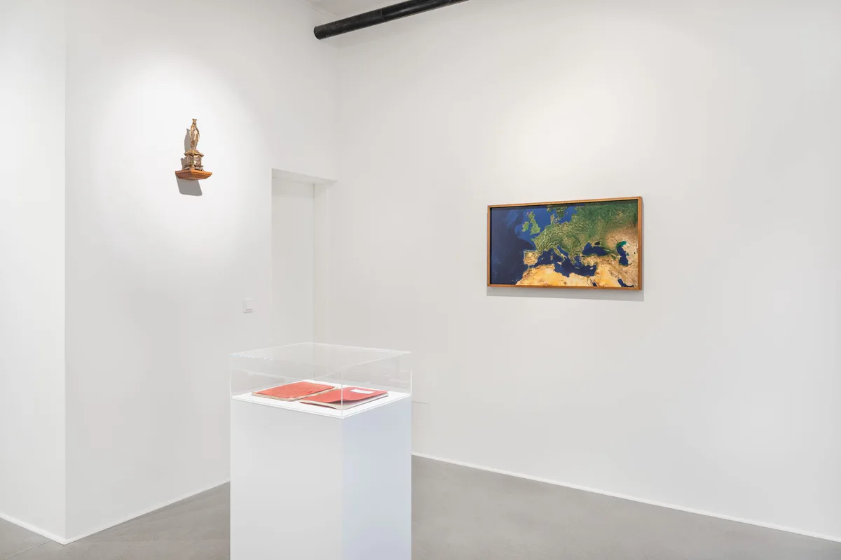 Marianische Antiphonen I, Ausstellungsansicht: Raum mit einer kleinen Figur an der Wand, einem Landschaftsbild und einer Vitrine