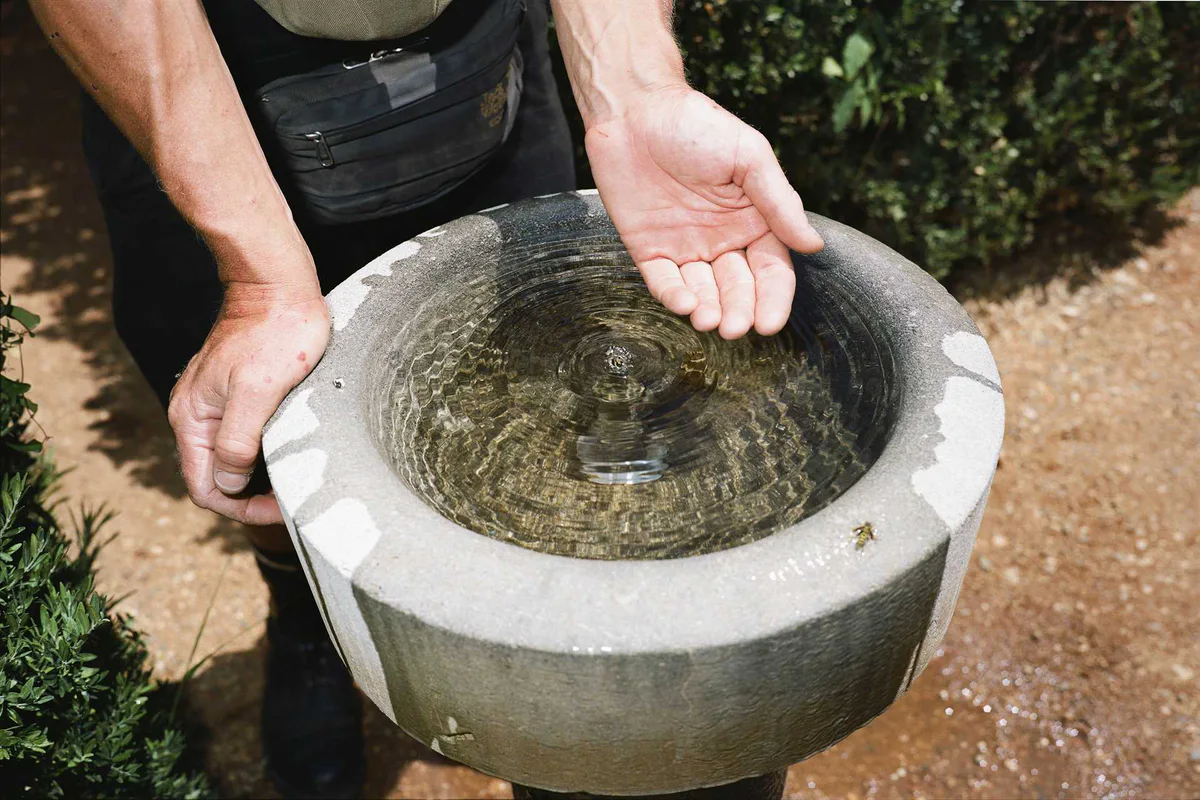 GABRIEL: zwei Hände halten ein steinernes Becken voll Wasser