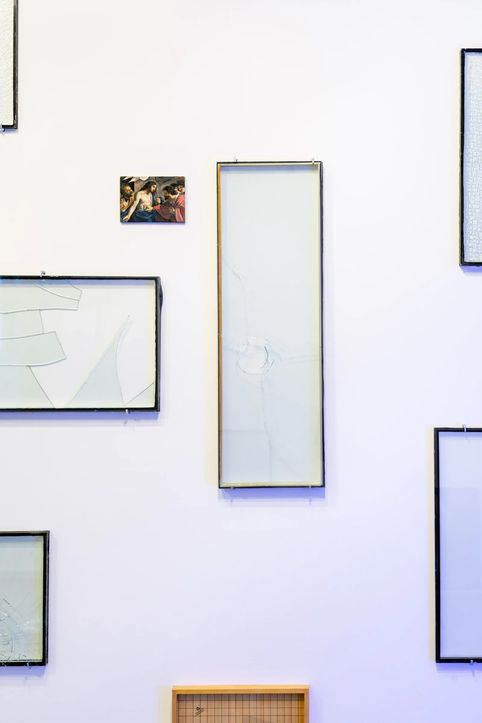 Installationsansicht: leere Glasrahmen in verschiedenen Formaten und ein kleines Bild an einer Wand