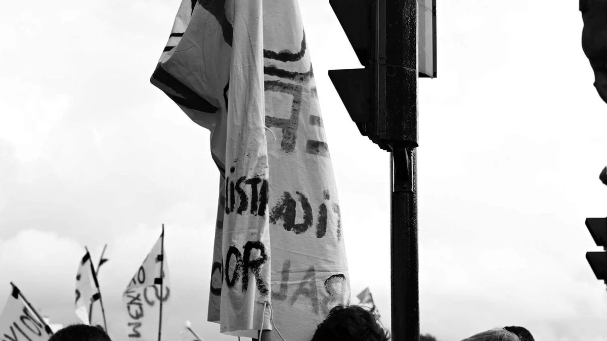 GABRIEL: Fahnen und Transparente einer Demonstration gegen den Himmel, Schwarz-Weiß