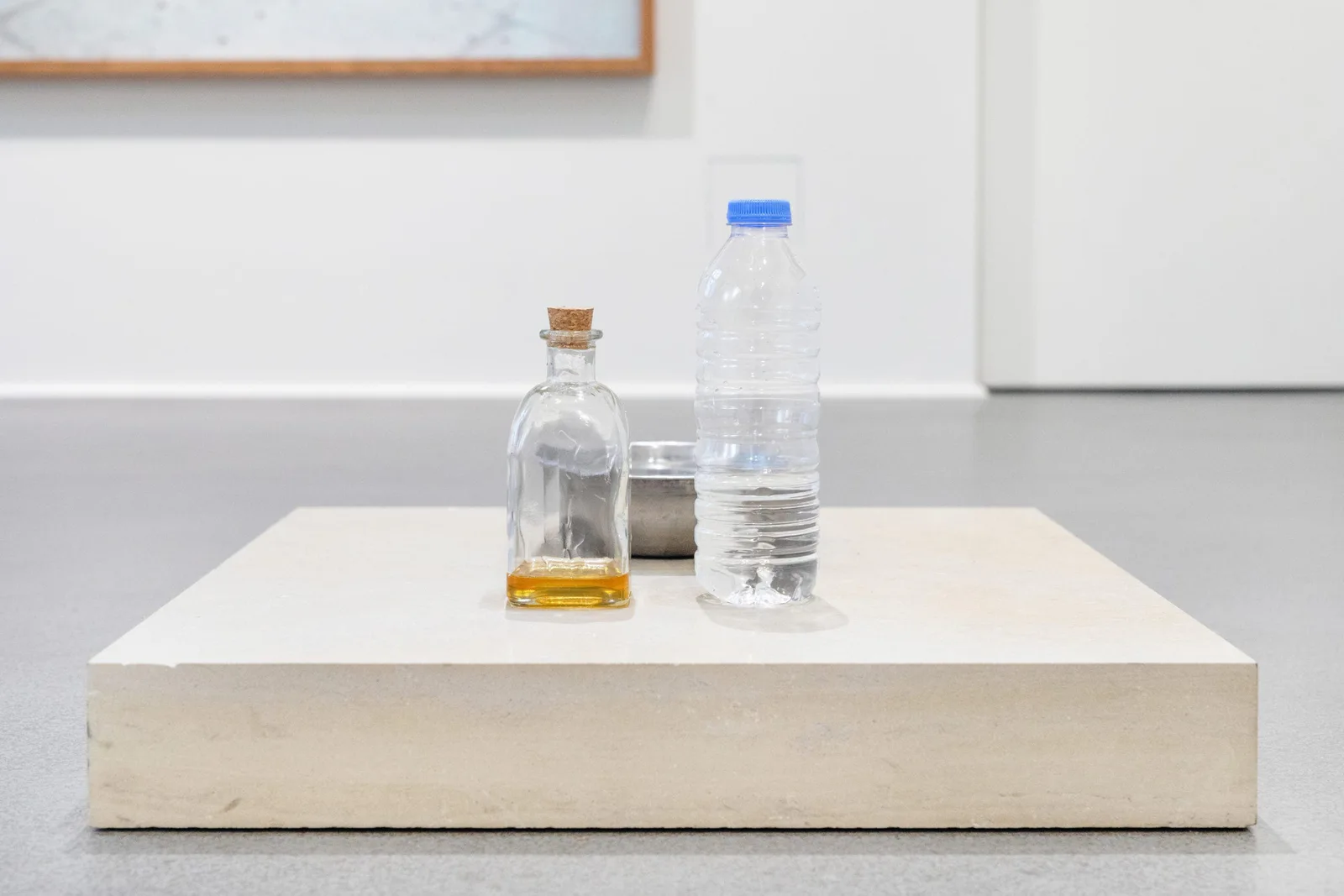 GABRIEL – Urraum Altar & Die Dritte Waschung oder die Honigtaufe (Werkzeuge), 2017–2019: eine Flasche Honig und eine Wasserflasche auf einem flachen weißen Sockel