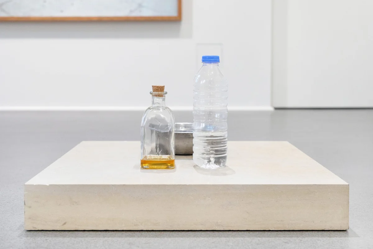 GABRIEL – Urraum Altar & Die Dritte Waschung oder die Honigtaufe (Werkzeuge), 2017–2019: eine Flasche Honig und eine Wasserflasche auf einem flachen weißen Sockel
