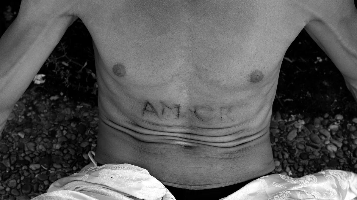 GABRIEL: nackter Oberkörper mit dem Wort „AMOR“ auf dem Bauch, Schwarz-Weiß