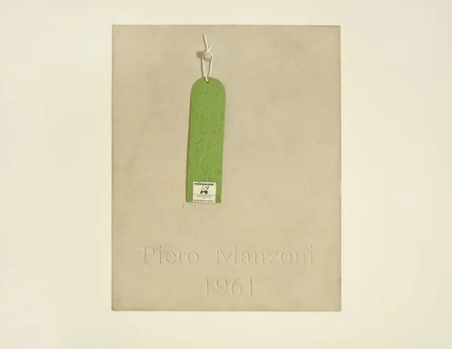 Gerahmtes helles Blatt mit einem grünen Anhänger und der Aufschrift „Piero Manzoni 1961“