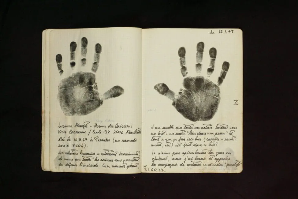Aufgeschlagenes Heft aus Bouqdibs Nachlass mit zwei Handabdrücken und handschriftlichen Notizen zur Handlesung, datiert 12.1.75