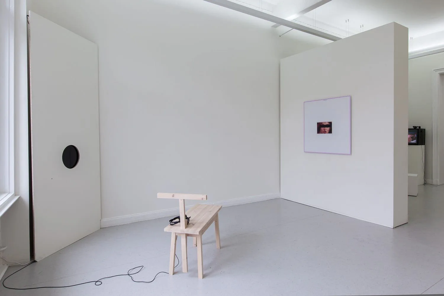 Installationsansicht mit Werken von Martin Bothe und Friedemann Heckel: ein Holzstuhl, ein kleines Bild auf einer Stellwand und eine schwarze Scheibe