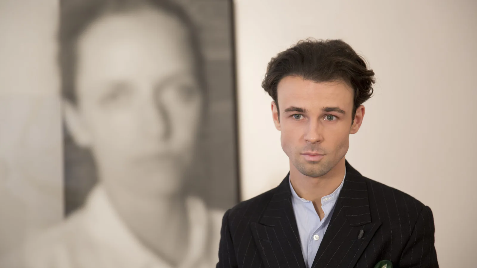 Michal Martychowiec im Gespräch mit dem chinesischen Fernsehsender CCTV, im Hintergrund ein Porträt