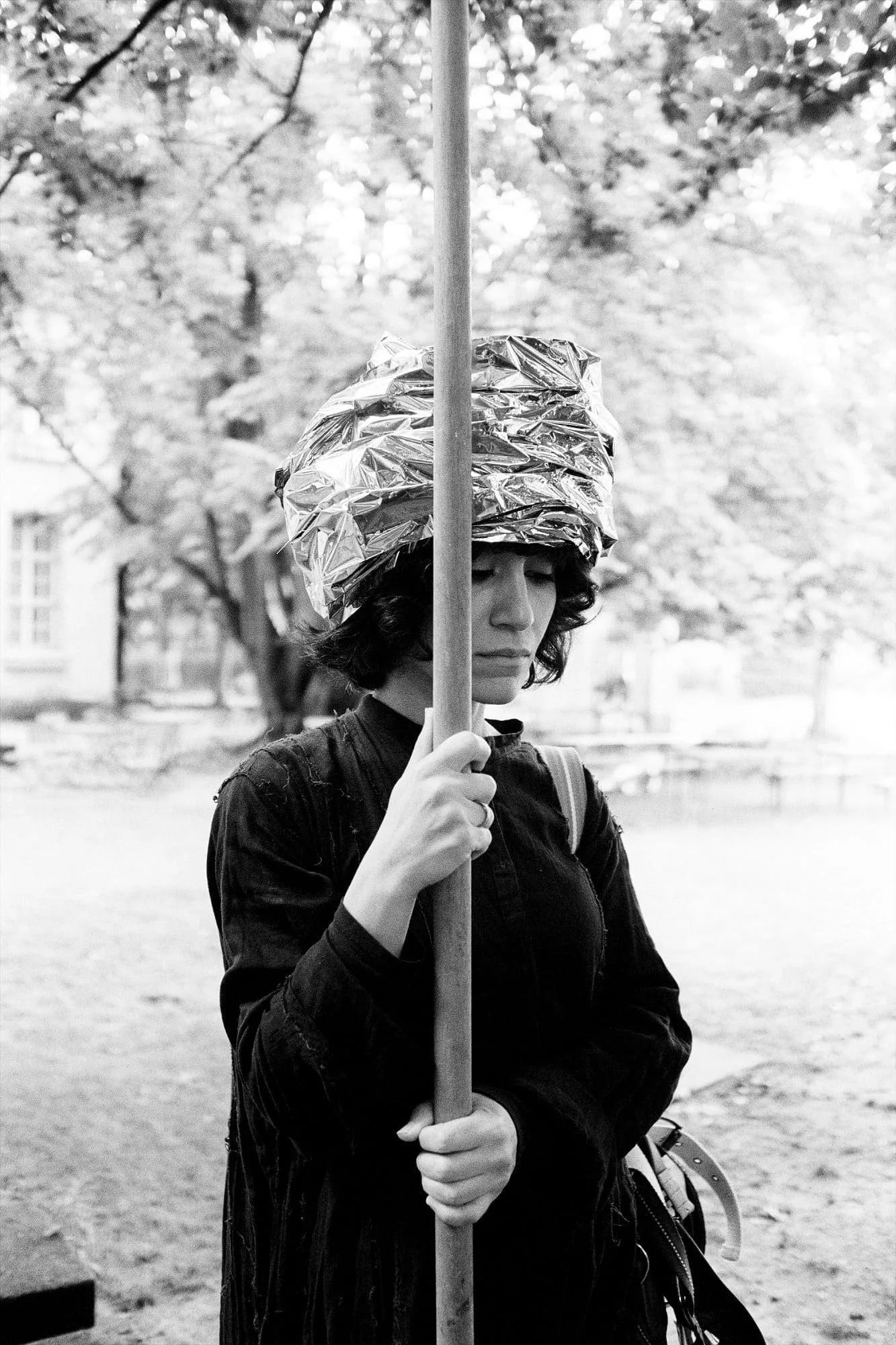 MNEMOSYNE Prelude – Die Könige – Letter of Politics or Rules for Kings: Performerin in schwarzem Gewand mit Turban hält eine lange Stange, Schwarz-Weiß