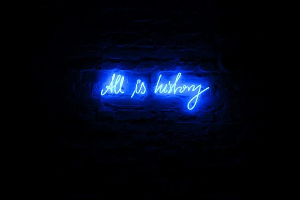 Michal Martychowiec – All is history, 2012: blaue Neonschrift „All is history“ an einer dunklen Wand