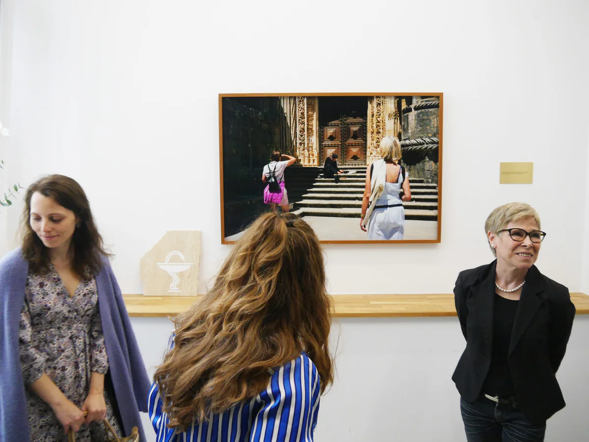 GABRIEL, Ausstellung: zwei Besucherinnen vor einer Fotografie von Kindern auf Kirchenstufen