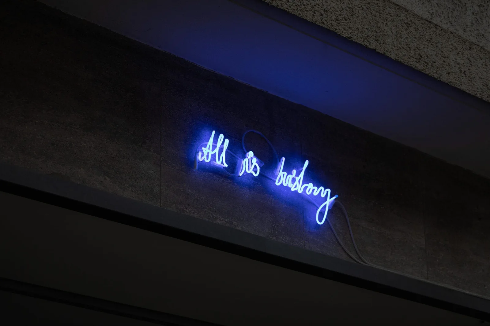 All is history, Installationsansicht: blaue Neonschrift „All is history“ an einer dunklen Decke