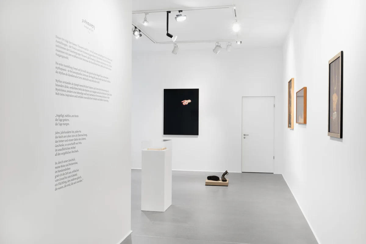 Tempel auf Zeit, Ausstellungsansicht: weißer Raum mit Wandtext, einem schwarzen Bild, einem Sockel und Rahmen