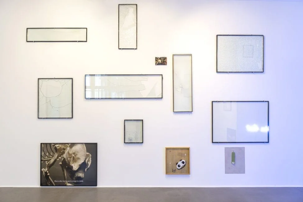 Nachricht vom letzten Menschen, Ausstellungsansicht: Wand mit leeren Glasrahmen in verschiedenen Formaten und kleinen Bildern
