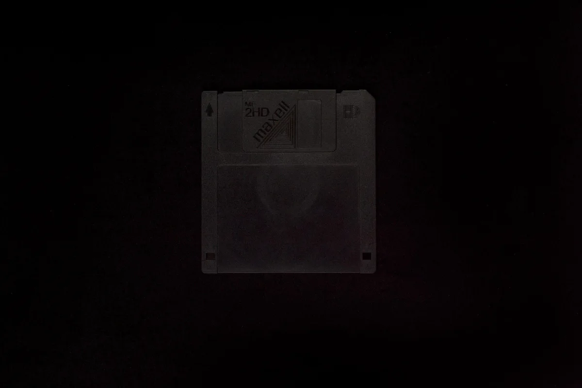 2-10 Schwarzer Monolith (unbekannt): eine schwarze 3,5-Zoll-Diskette, kaum sichtbar vor schwarzem Hintergrund