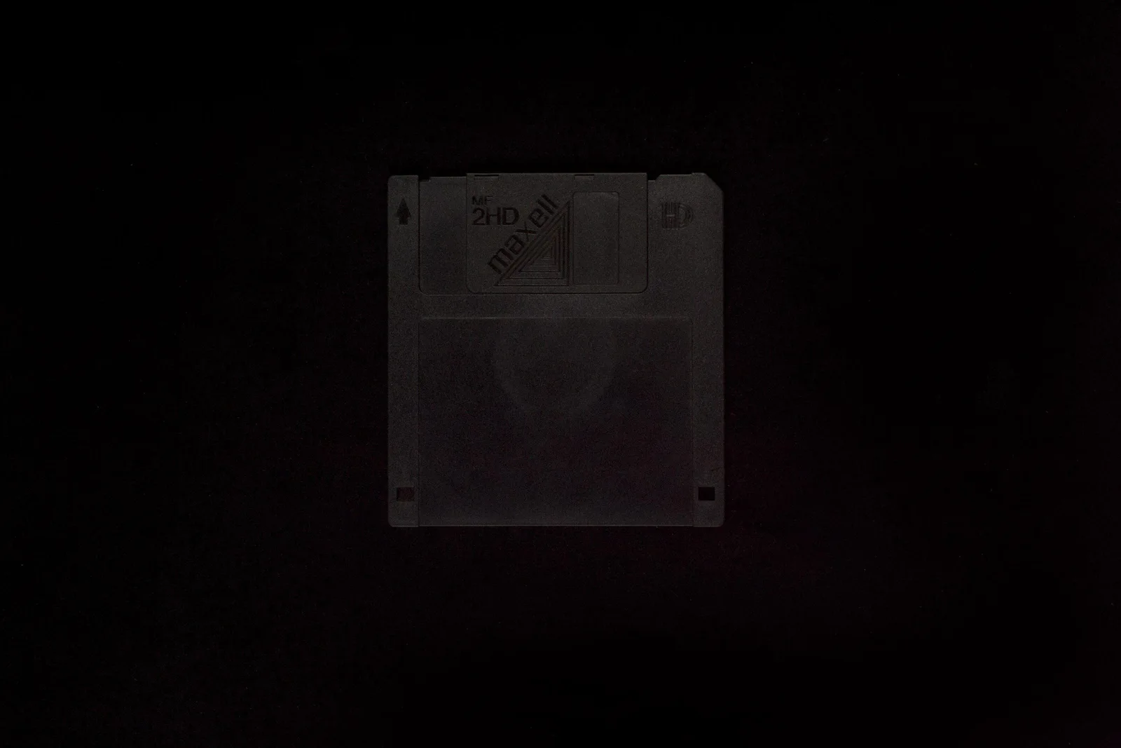 2-10 Schwarzer Monolith (unbekannt): eine schwarze 3,5-Zoll-Diskette, kaum sichtbar vor schwarzem Hintergrund