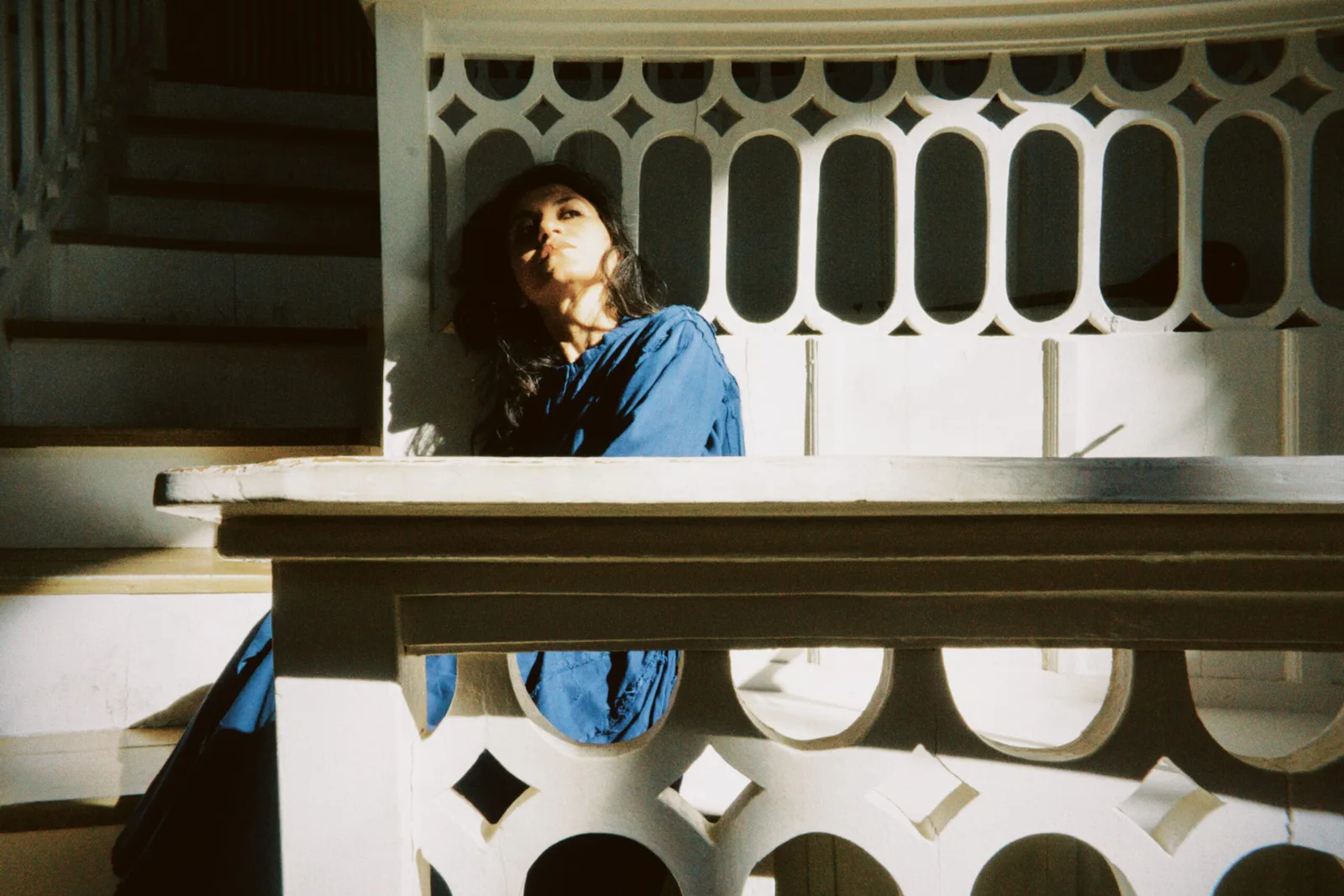 Elshan Ghasimi in blauer Bluse hinter einer steinernen Balustrade im Sonnenlicht, Foto Arnaud Ele
