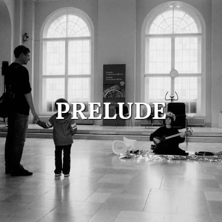 Mnemosyne Prelude: Performerin sitzt in einem Saal mit hohen Fenstern, ein Vater mit Kind sieht zu, Schwarz-Weiß, Schriftzug über dem Bild