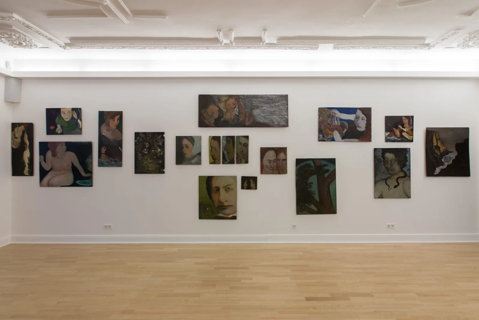Installationsansicht: Wand mit dicht gehängten Gemälden von Hilarion Manero
