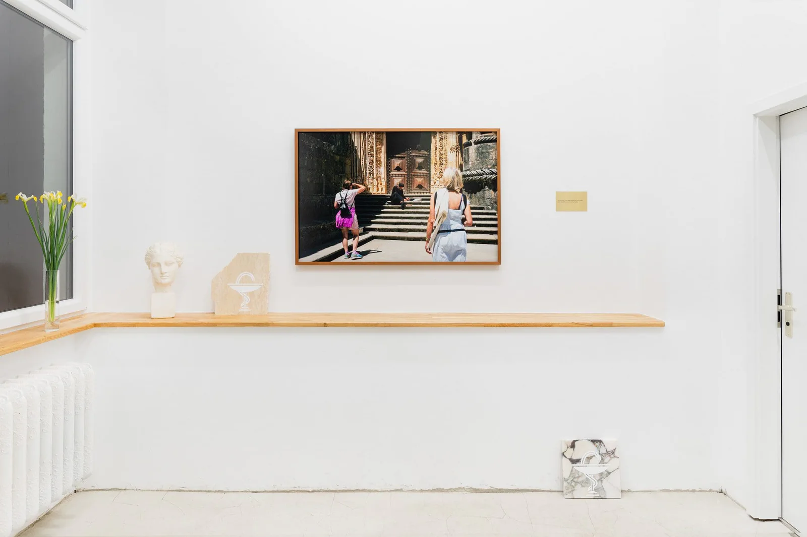 Marianische Antiphonen I – III, Ausstellungsansicht: gerahmte Fotografie über einer Holzkonsole mit Büste und Blumen