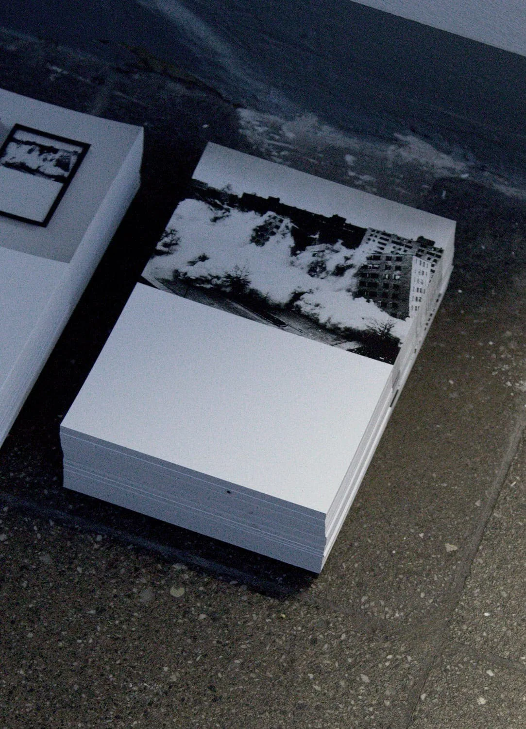 The road leads back and back to the black square: Stapel von Fotodrucken einer Baumreihe auf dem Boden