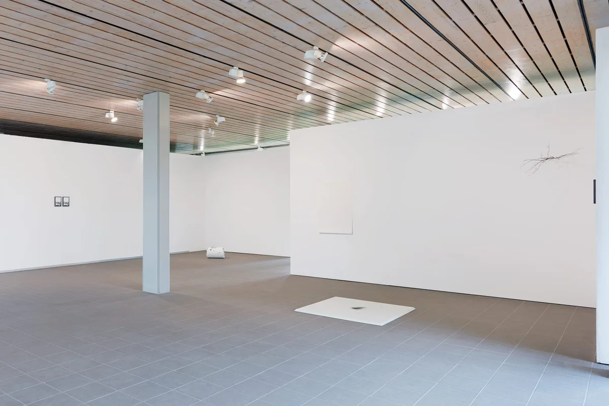 The road leads back and back to the black square: Ausstellungshalle mit Holzdecke, kleinen Rahmen und einem Objekt auf dem Boden