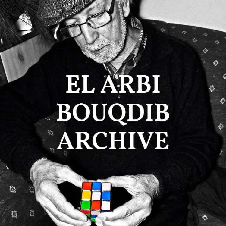 El Arbi Bouqdib Archive: ein älterer Mann mit Hut hält einen Zauberwürfel, Schwarz-Weiß, Schriftzug über dem Bild