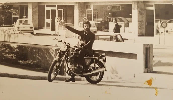 El Arbi Bouqdib on a motorcycle in front of a building, old black-and-white photograph