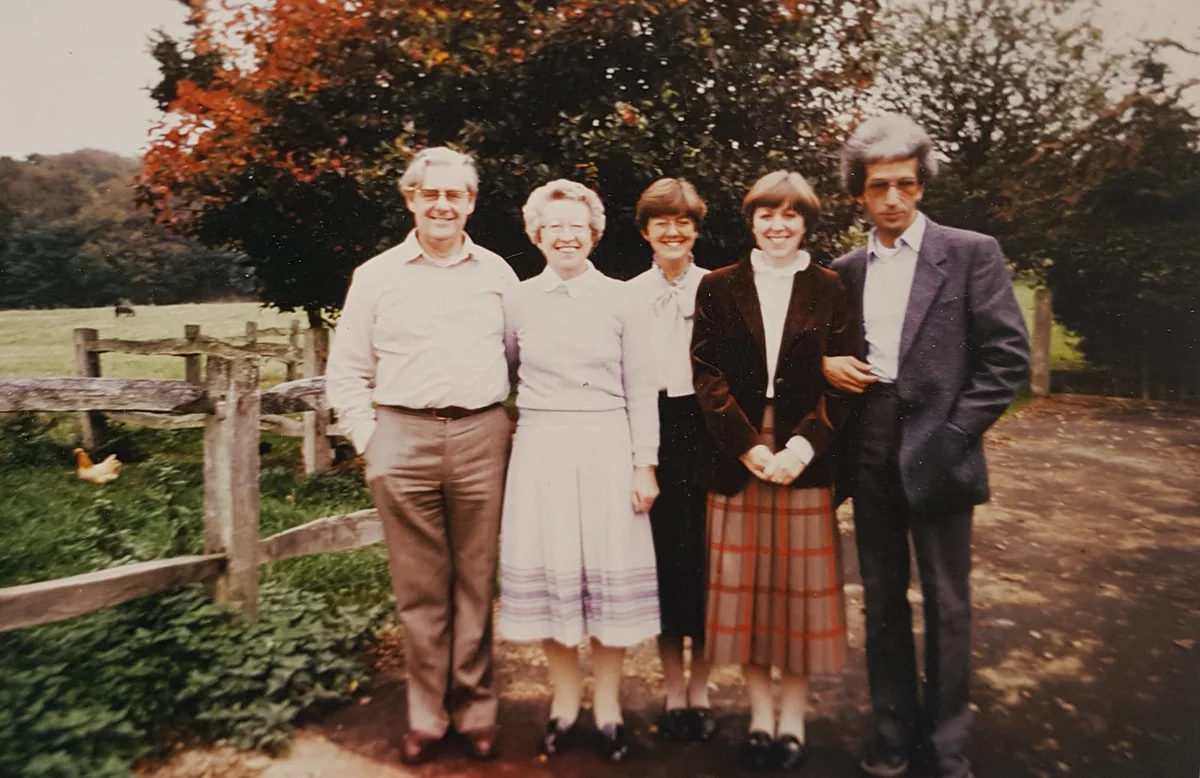 Family photo: El Arbi Bouqdib with four people in front of a fence in an autumn garden