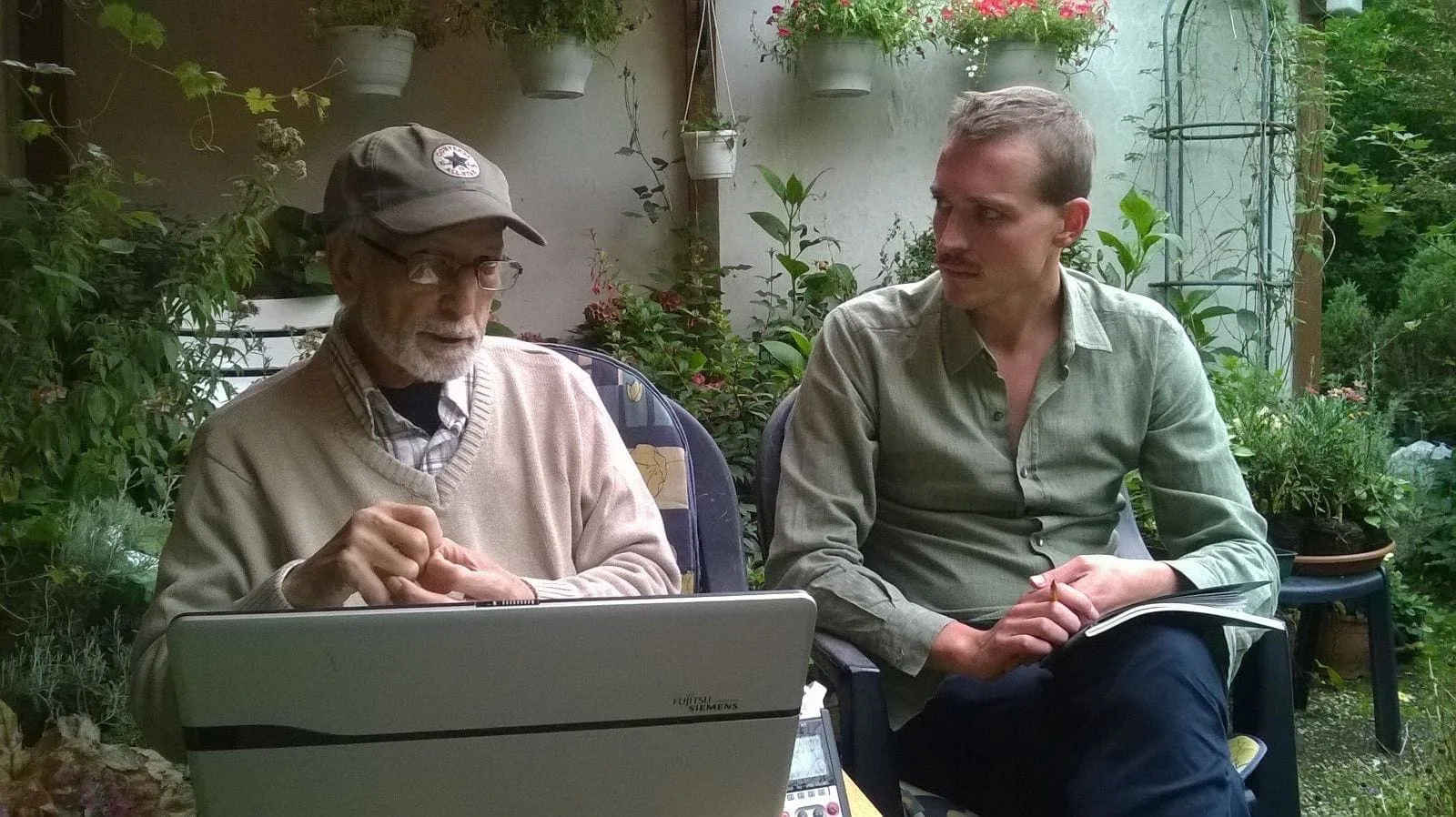 Im Gespräch mit El Arbi Bouqdib im August 2015: zwei Männer sitzen mit einem Laptop in einem Garten