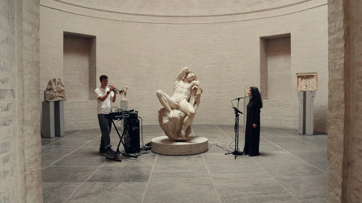 Zirkular 9/25: zwei Musiker vor einer antiken Marmorskulptur in einer Rotunde eines Museums